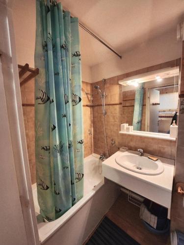 a bathroom with a shower curtain and a sink at Cocon Montagne Vue exceptionnelle Pra-Loup 1500 in Uvernet