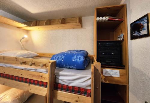a room with a bunk bed with a blue pillow on it at Cocon Montagne Vue exceptionnelle Pra-Loup 1500 in Uvernet