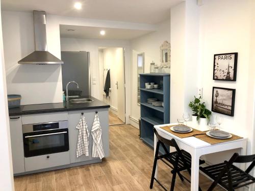 a kitchen and dining room with a table and a stove at Le Petit Ekrin des Ursines in Vélizy-Villacoublay