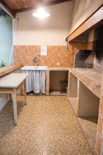 a kitchen with a counter and a sink and a stove at Casa Rural la Quinteria de Sancho piscina para tres apartamentos in Argamasilla de Alba
