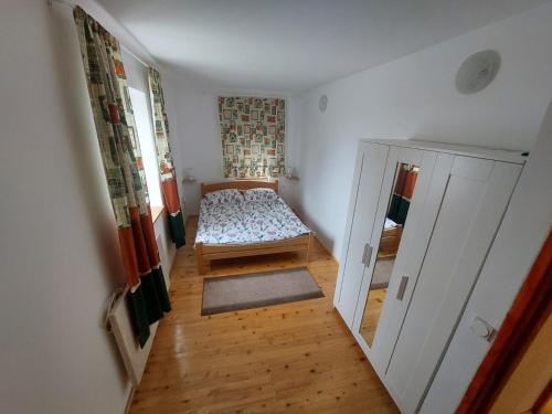 a small bedroom with a bed and a mirror at Guest house Griva Plitvice in Korenica