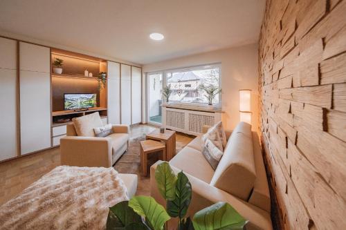 ein Wohnzimmer mit Sofa und Tisch in der Unterkunft Moderne Ferienwohnung mit Ifenblick, Panorama & Parkplatz in Oberstdorf