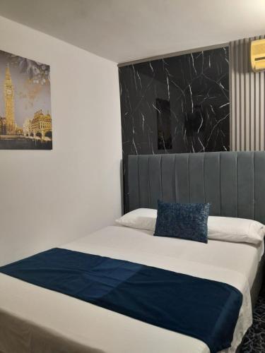 a bedroom with a bed with a blue pillow on it at Bahia Suite Alojamiento Centro historico in Santa Marta