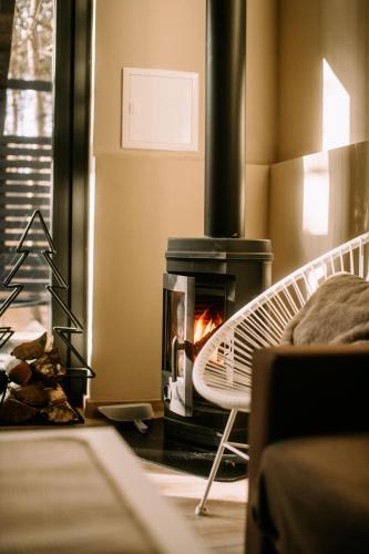 a fireplace in a living room with a stove at Domek SzumiSosna2 in Życiny