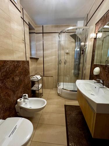 a bathroom with a toilet and a sink and a shower at Pensjonat Klimek in Muszyna