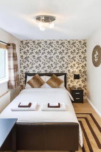 a bedroom with a large white bed with a black headboard at Private Room Near Excel London & City Airport Free Parking Available & WiFi in North Woolwich