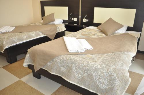 a group of three beds in a room at Anna Mariya Villa in Kurortne