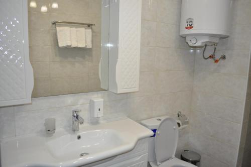 a white bathroom with a sink and a toilet at Anna Mariya Villa in Kurortne