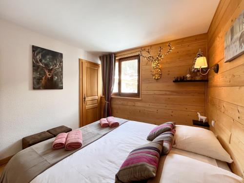 a bedroom with a large bed with pink pillows on it at Duplex Les Gets Centre Local VTT Sécurisé & Balcon 6P in Les Gets