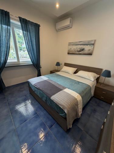 a bedroom with a large bed and two windows at Casa Restituta in Lacco Ameno