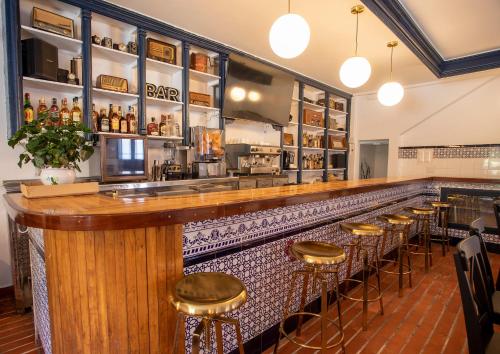 a bar with a row of stools in a restaurant at Hotel Boutique Las dos Peñas in Mier