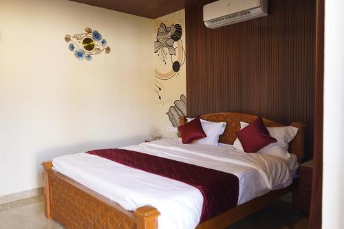 a bedroom with a bed with white sheets and red pillows at Eleven Eleven Villa in Pondicherry