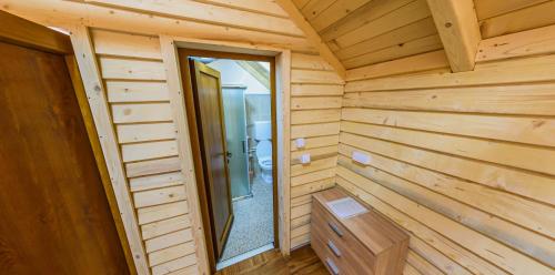 a wooden cabin with a walk in shower and a door at Vidikovac Uvac in Družiniće