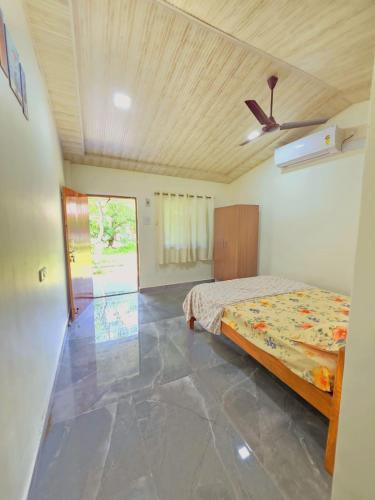 a bedroom with a bed and a ceiling fan at Chandrachhaya Agro Farms Boisar in Boisar