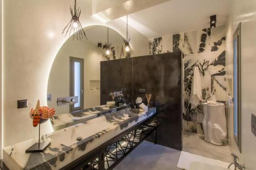 a bathroom with three sinks and a large mirror at Callirhoe 180 in Poros