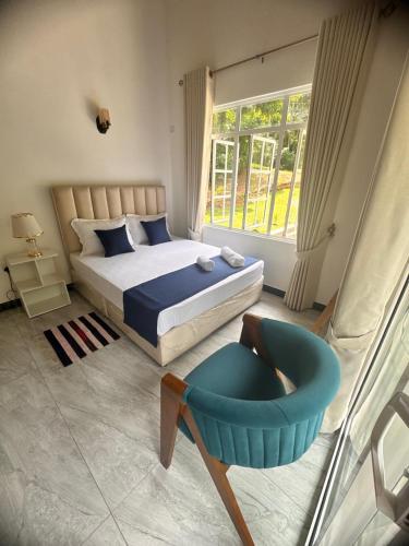 a bedroom with a bed and a chair and a window at Blue Rock Retreat in Belihuloya