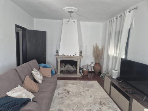 a living room with a couch and a fireplace at Casa Calçada in Asnela