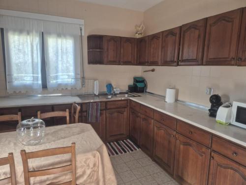 a kitchen with wooden cabinets and a table and a microwave at Casa Calçada in Asnela