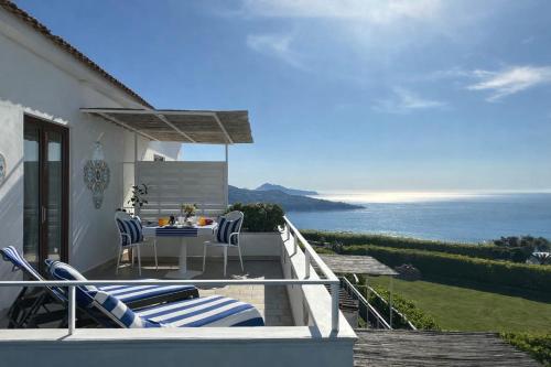 a patio with a table and chairs and the ocean at Villa Raf in Vico Equense