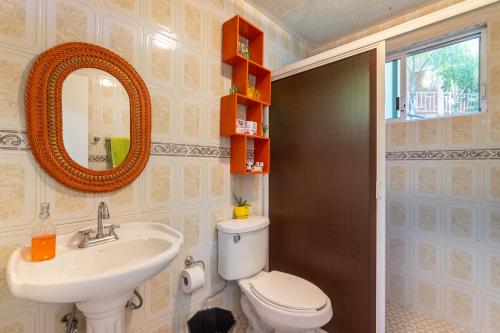 a bathroom with a toilet and a sink and a mirror at Casa divertida para grupos Plan prémium sin romper la quincena in Tequisquiapan