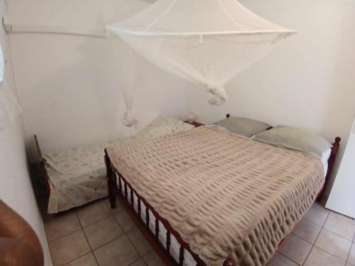 a small bedroom with a bed in a room at Résidence EmiRose in Rivière-Pilote