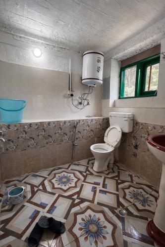 a bathroom with a toilet and a sink at Jungle Bungalow in Pahalgām