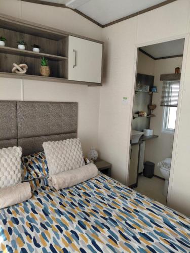 a bedroom with a bed with two pillows on it at Hoburne Devon Bay - 2 Bed Caravan - Activity Passes Included in Goodrington