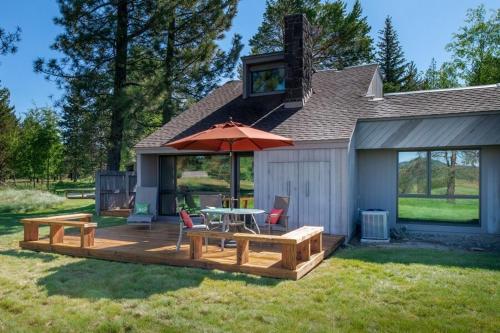 a wooden deck with a table and an umbrella at 63 Meadow House in Sunriver