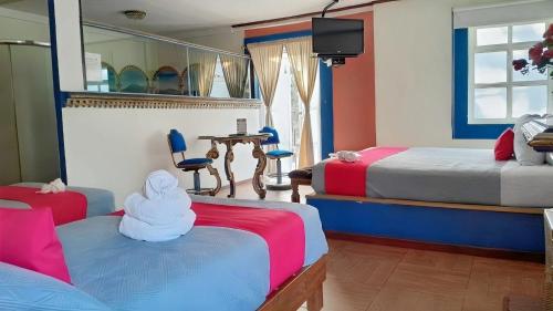 a hotel room with two beds and a mirror at Mesón Yollotl in Puebla