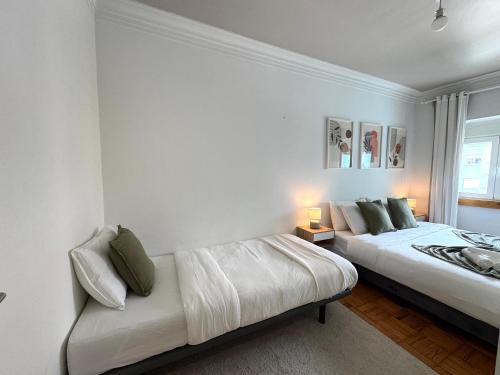 a bedroom with two beds and a couch in it at Aura Campo de Ourique - Near the Tram 28 stop in Lisbon