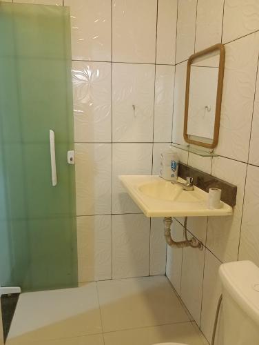 a bathroom with a sink and a shower with a mirror at Renascer in São Pedro da Aldeia