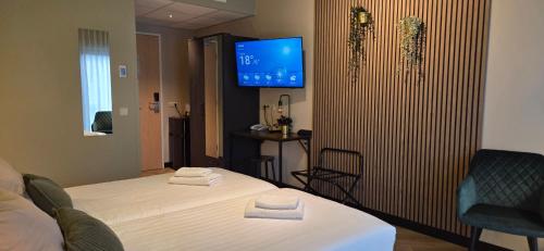 a hotel room with a bed and a tv at Hotel Restaurant 't Trefpunt in Made