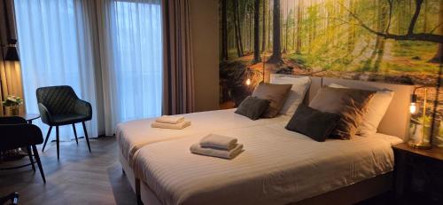 a bedroom with a bed with towels on it at Hotel Restaurant 't Trefpunt in Made