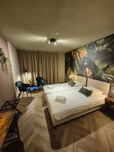 a bedroom with a bed and a painting on the wall at Hotel Restaurant 't Trefpunt in Made