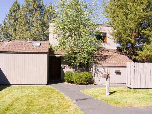 a house with a white garage and a fence at 61 Meadow House in Sunriver