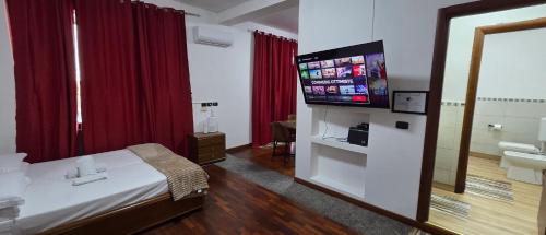 a hotel room with a bed and a flat screen tv at Casa Manzoni in Novara