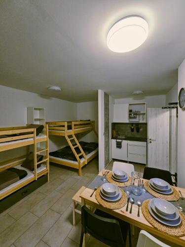 a dining room with a table and two bunk beds at Apartmány u Mravence in Starý Petřín