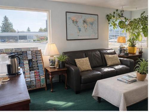 a living room with a leather couch and a map on the wall at Marco Polo Motel in Seattle