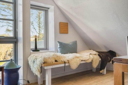 a room with a bench with a blanket and a window at LN2056-Hjorring-Strandvejen-56 in Lønstrup