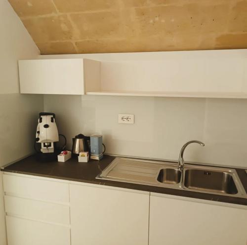 a kitchen with a sink and a counter top at Alma Mater Suite in Matera