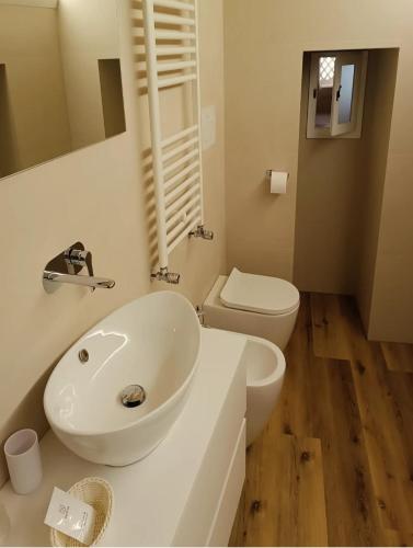 a bathroom with a white sink and a toilet at Alma Mater Suite in Matera