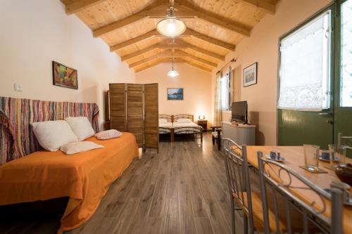 a bedroom with a bed and a desk in a room at Joya's Little Farm Cottage in Svoronata