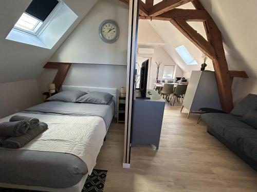 a bedroom with a bed and a living room at Logement climatisé avec cuisine équipée in Amboise