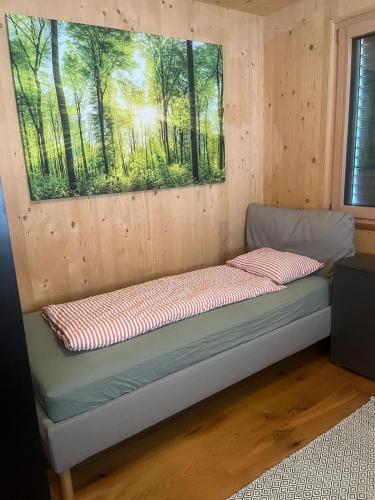 a bed in a room with a painting on the wall at Ferienwohnung MARTIN in Göfis