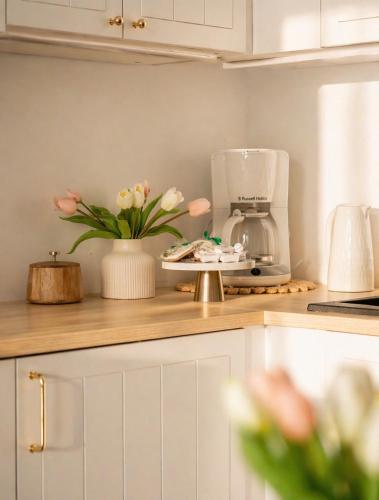a kitchen counter with a vase of flowers on it at Baltic Harmony - Easy-Rent Apartments in Pobierowo