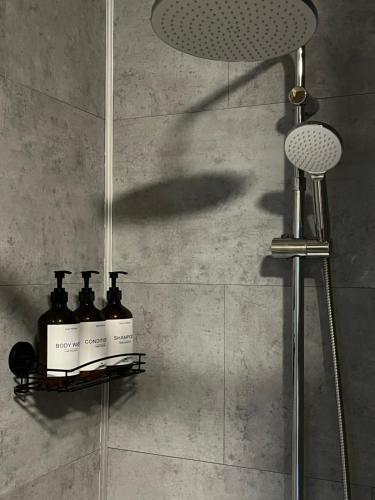 a shower with three bottles on a shelf in a bathroom at SomeTimes in Roeselare