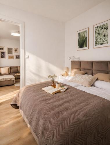 a bedroom with a large bed with a tray on it at Baltic Harmony - Easy-Rent Apartments in Pobierowo