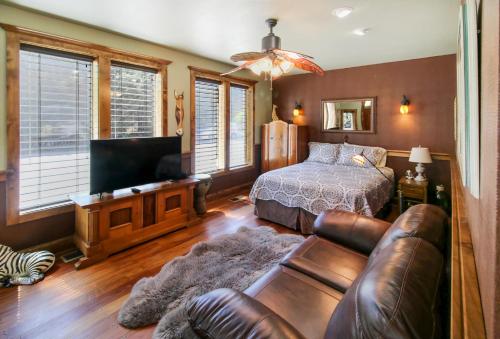 a bedroom with a bed and a couch and a television at Safari Cottage in Jacksonville