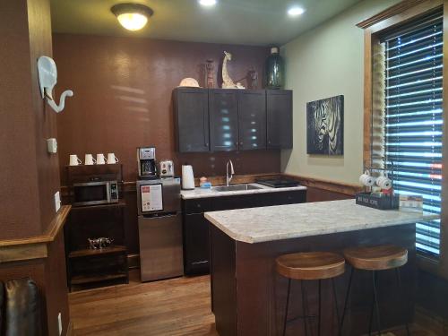 a kitchen with a sink and a counter with stools at Safari Cottage in Jacksonville
