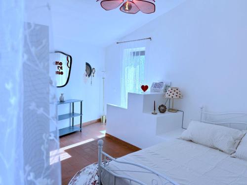 a white bedroom with a bed and a window at Garden House - InBorgo in Acquasparta